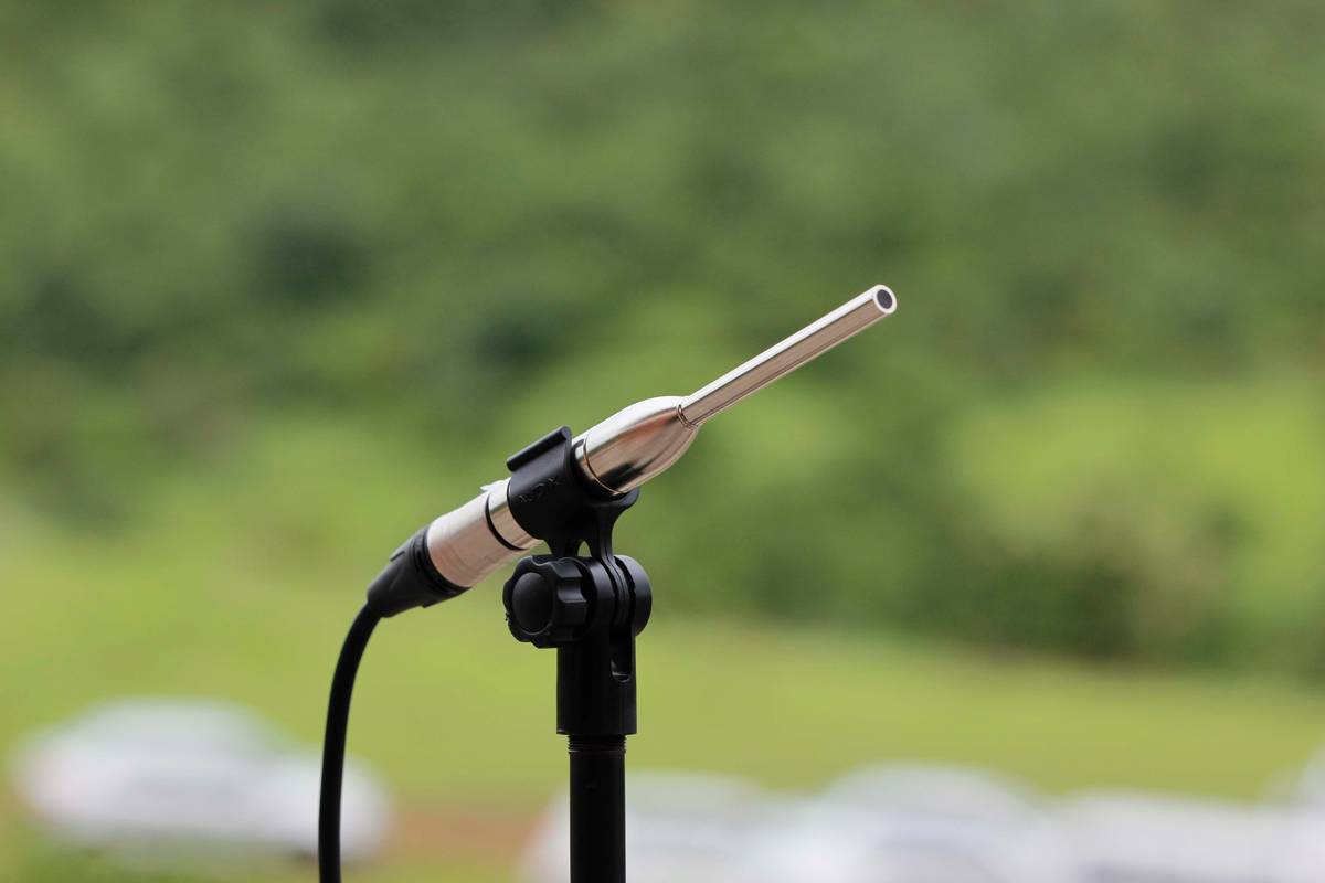 Comparison chart of top travel wireless mics: DJI Mic 2, Rode Wireless GO II, Hollyland Lark M2 showing size, battery life, wind resistance, and price